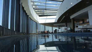 An indoor swimming pool with a modern design, large windows, and seating areas. - ASBU Hotel (Tunis)