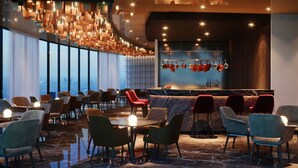 A modern restaurant with a bar area, seating arrangement, and a city view. - ASBU Hotel (Tunis)