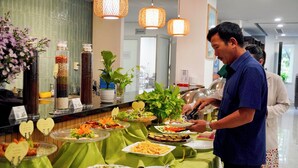 Un buffet proposant une variété de plats et une personne qui sert les clients.
