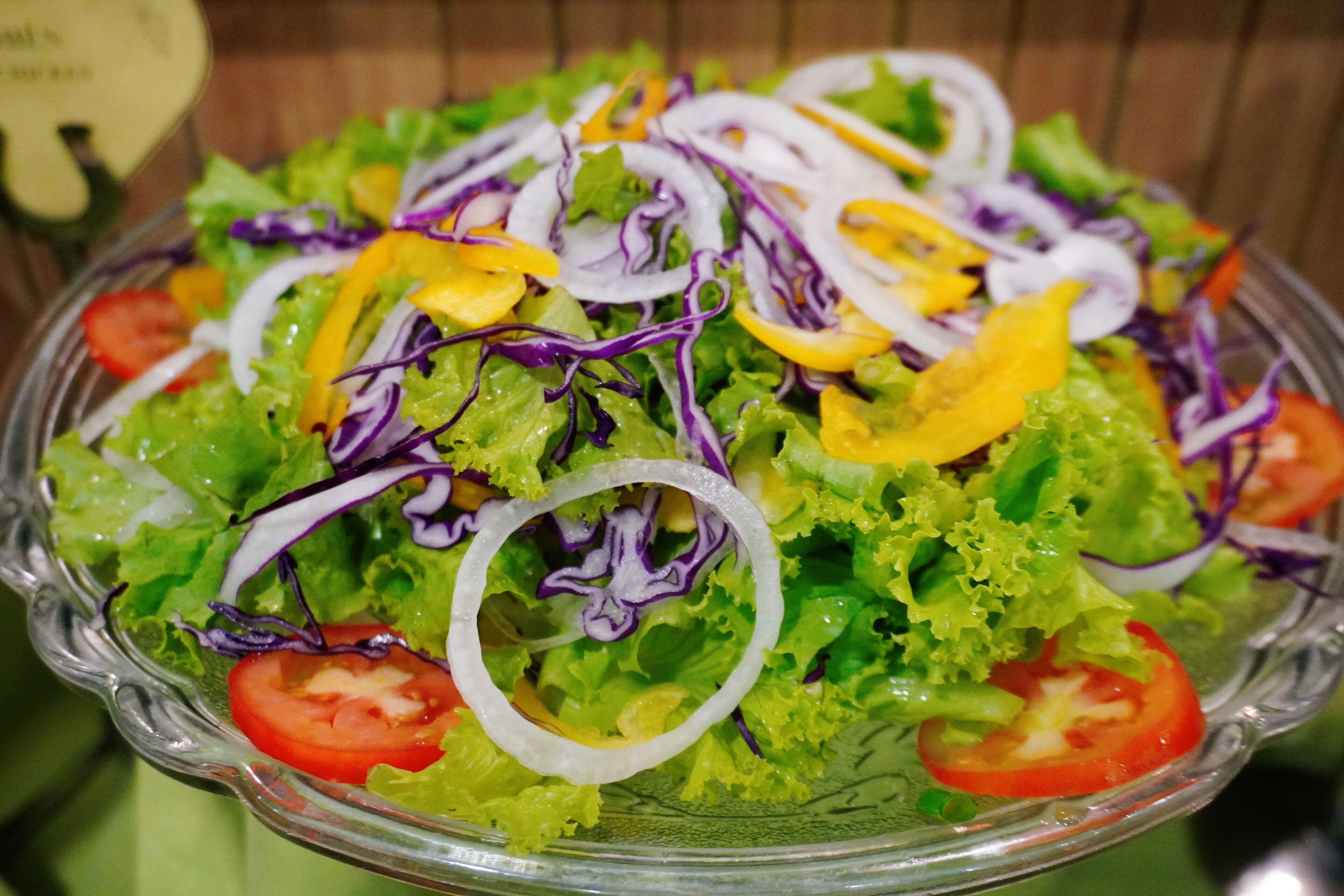 A glass bowl filled with a salad.