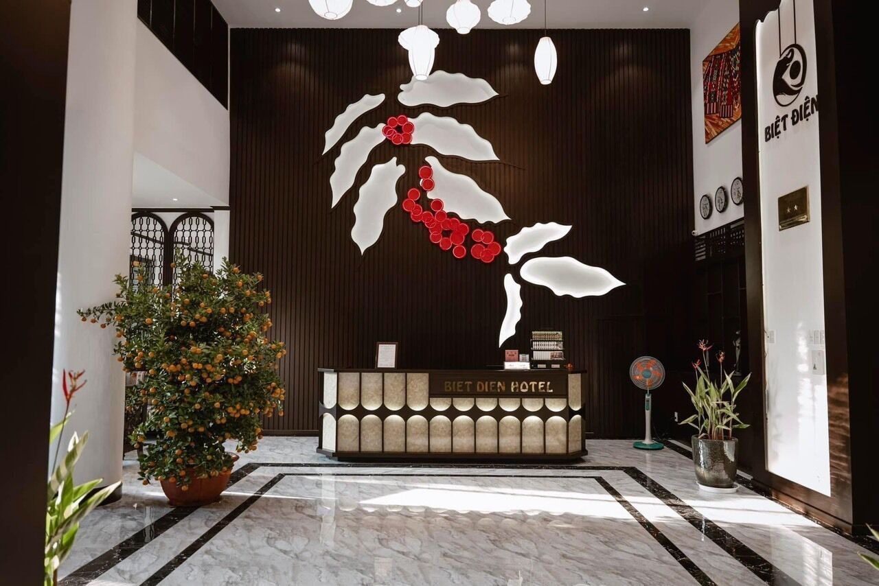 Un comptoir d’accueil d’hôtel au design moderne, agrémenté d’une grande œuvre d’art murale et d’une plante en pot.