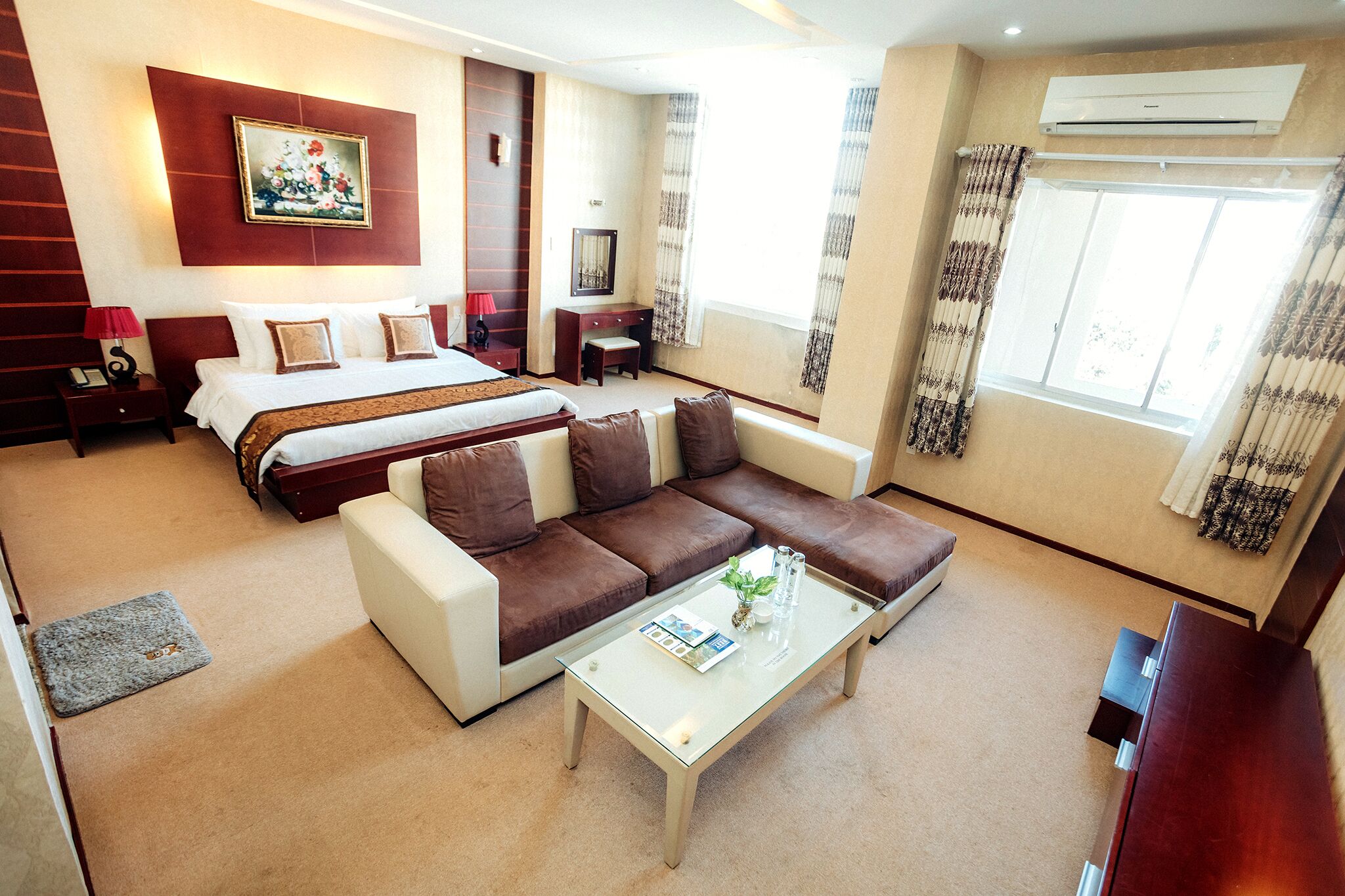 Una habitación de hotel con cama, sofá, mesa de centro y escritorio con silla.