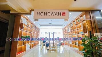 A bookstore interior with shelves, a sign reading 'HONGWAN,' and a few people seated.