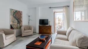 A modern living room with two sofas, a coffee table, a TV on a wooden cabinet, and a large map on the wall. - San Marcos. 2 bedrooms, 2 bathrooms (Sevilla)