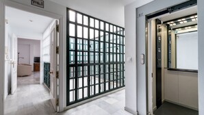 A hallway with a glass partition, an elevator, and a sign reading "Second Floor". - San Marcos. 2 bedrooms, 2 bathrooms (Sevilla)