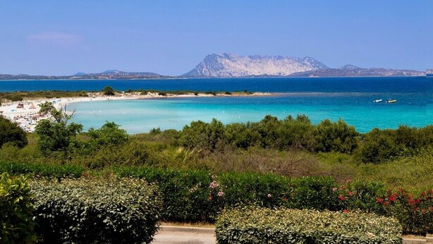 A coastal landscape with a beach, clear blue sea, and a mountain in the background. - Apartment "Ida Isuledda 2" with Pool, Garden & Wi-Fi (San Teodoro)