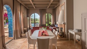 Un espace repas comprenant une table, des chaises et donnant sur l’extérieur.