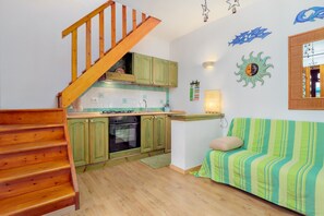 A kitchen with wooden cabinets, a stove, and a sink.