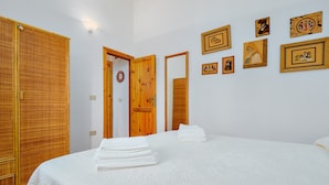 Une chambre d’hôtel avec un lit, une armoire et un mur orné de tableaux.