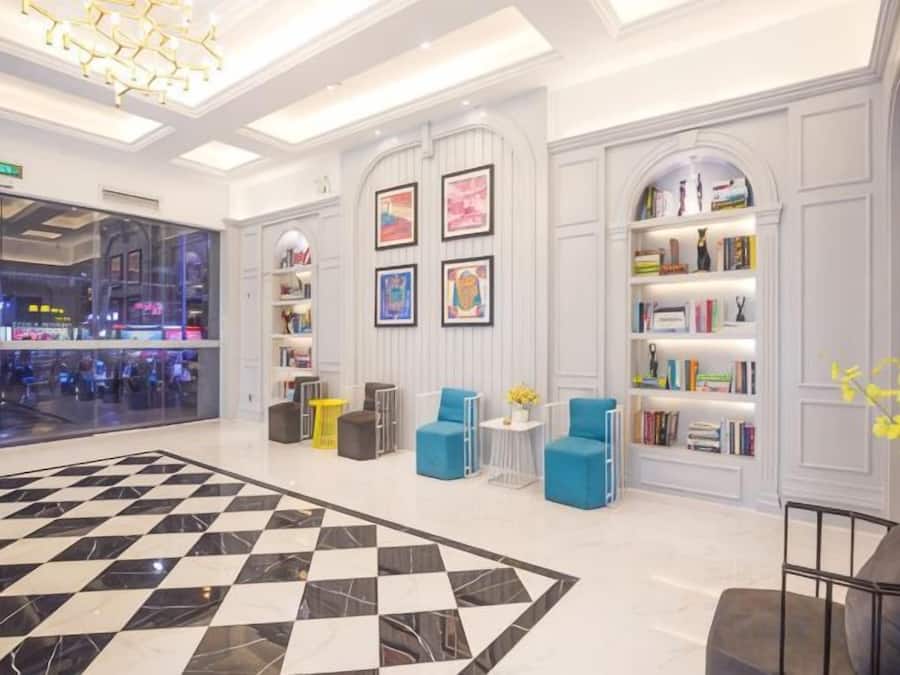 A lobby with a checkered floor, seating areas, and bookshelves.