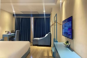 A hotel room with a bed, a desk, a chair, a TV, and a large window with curtains. - Haikou Dream House Hotel (Nansha Road) (Haikou)