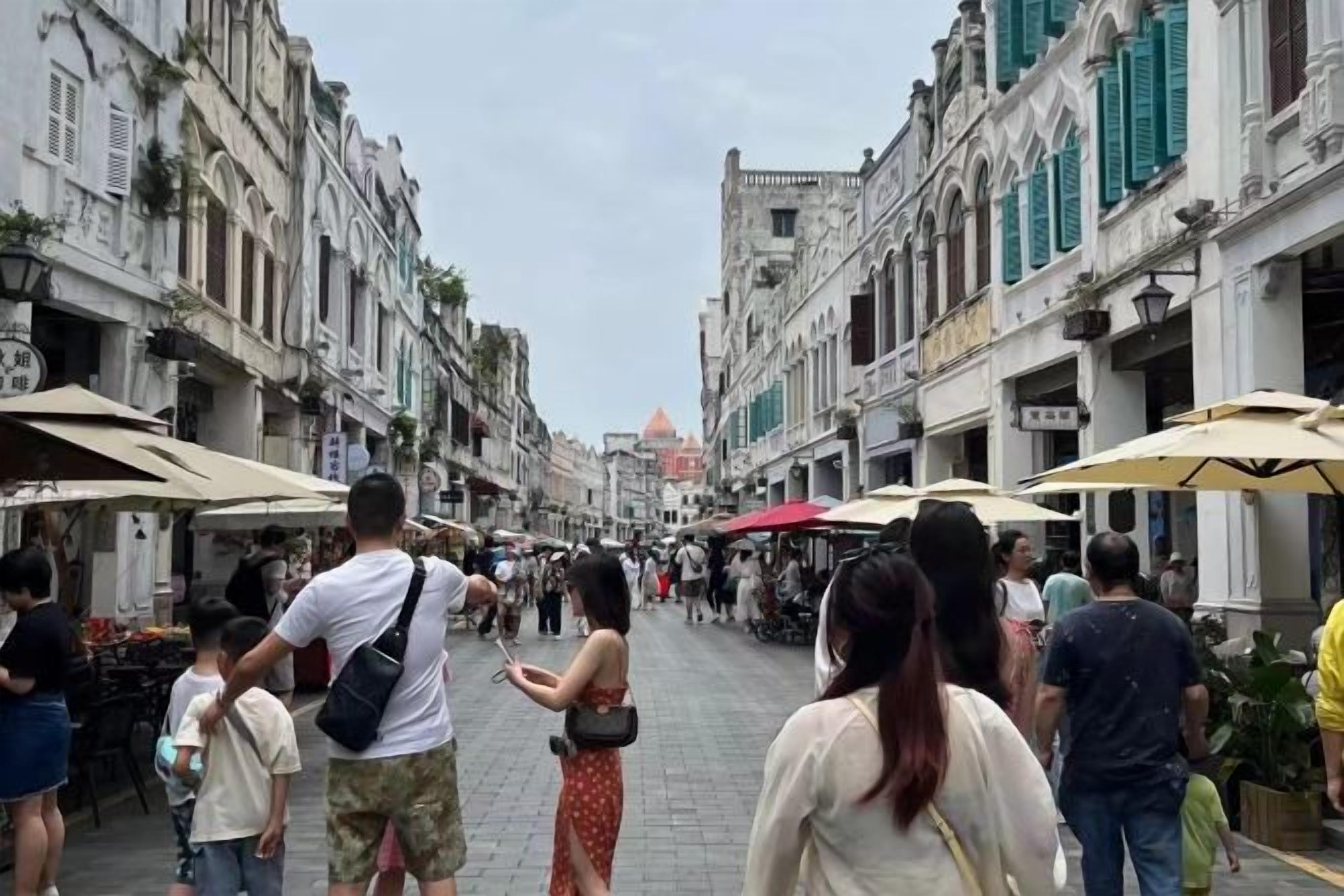A bustling street with pedestrians, outdoor cafes, and historic buildings.