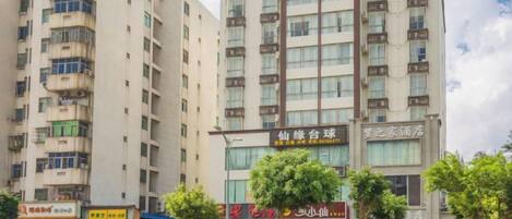 Un edificio de varios pisos con locales comerciales en la planta baja, incluyendo un restaurante y una tienda.