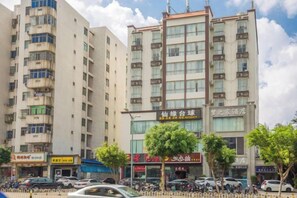A multi-story building with commercial establishments on the ground floor, including a restaurant and a shop. - Haikou Dream House Hotel (Nansha Road) (Haikou)