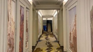A hallway with a patterned carpet and framed artwork on the walls. - Haikou Dream House Hotel (Nansha Road) (Haikou)