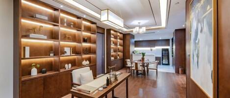 A modern interior with wooden shelving, a dining area, and a large painting.