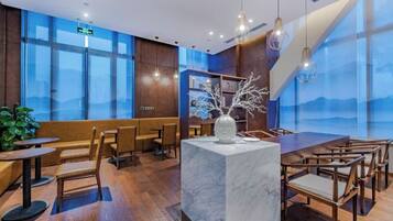 A modern interior with a marble island, wooden furniture, and large windows offering a view.