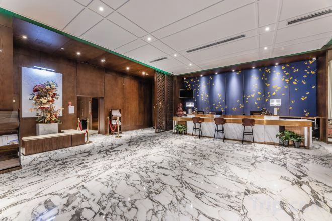 A hotel lobby with a reception desk, bar area, and seating.