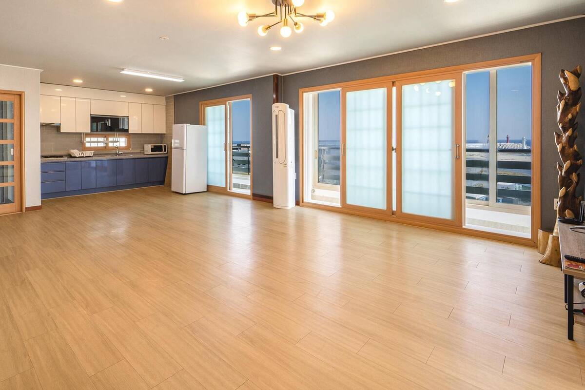 A spacious kitchen with modern appliances, large sliding glass doors, and a view of the city.