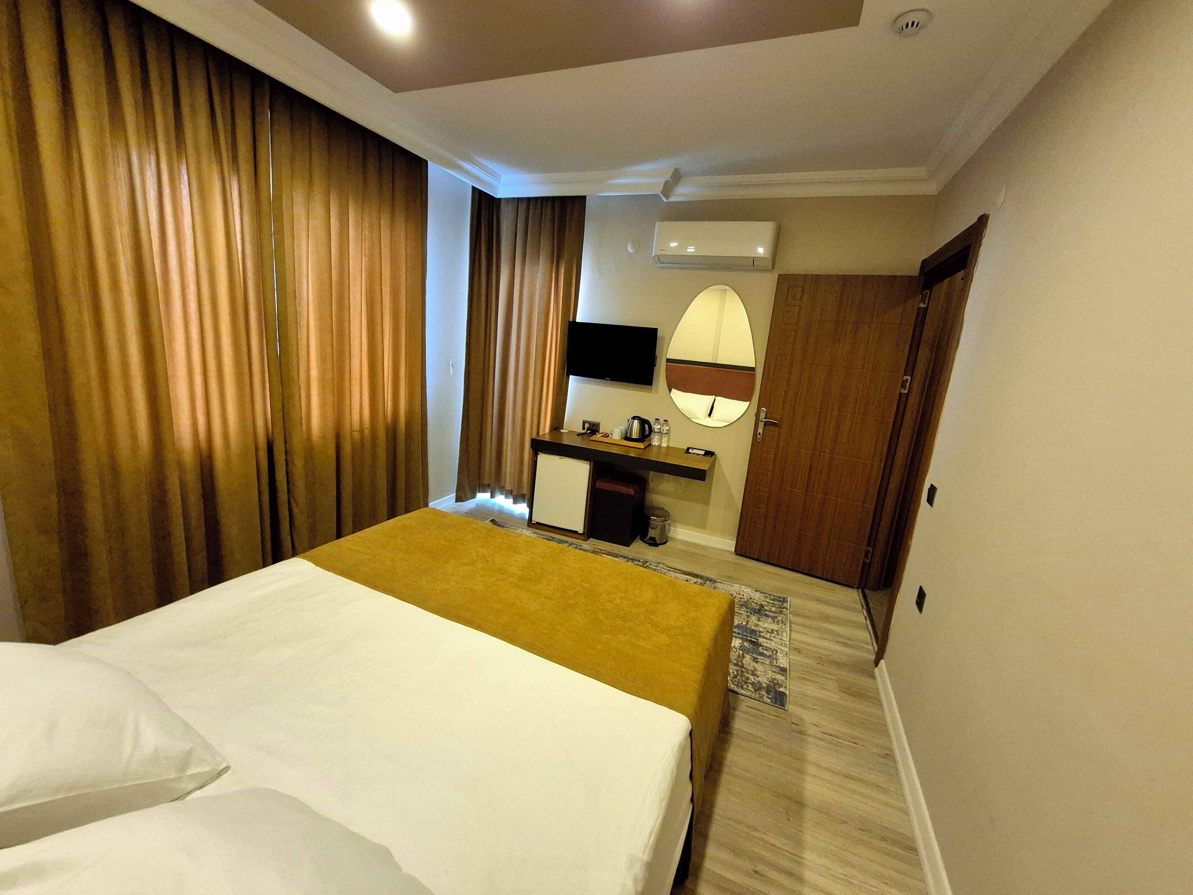 Une chambre d’hôtel équipée d’un lit, d’un bureau, d’un miroir et d’un appareil de climatisation.