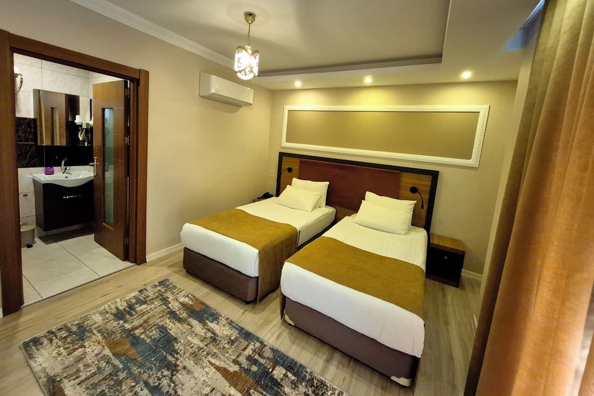 Ein Hotelzimmer mit zwei Betten, einem Badezimmer und einem Flur.