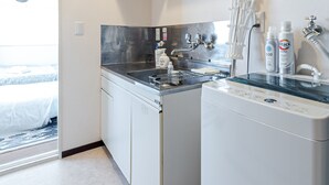 A compact kitchen with a stainless steel stove, white cabinets, and a built-in dishwasher.