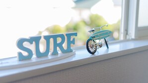 A window sill with a blue bicycle and the word "SURE" in white letters.
