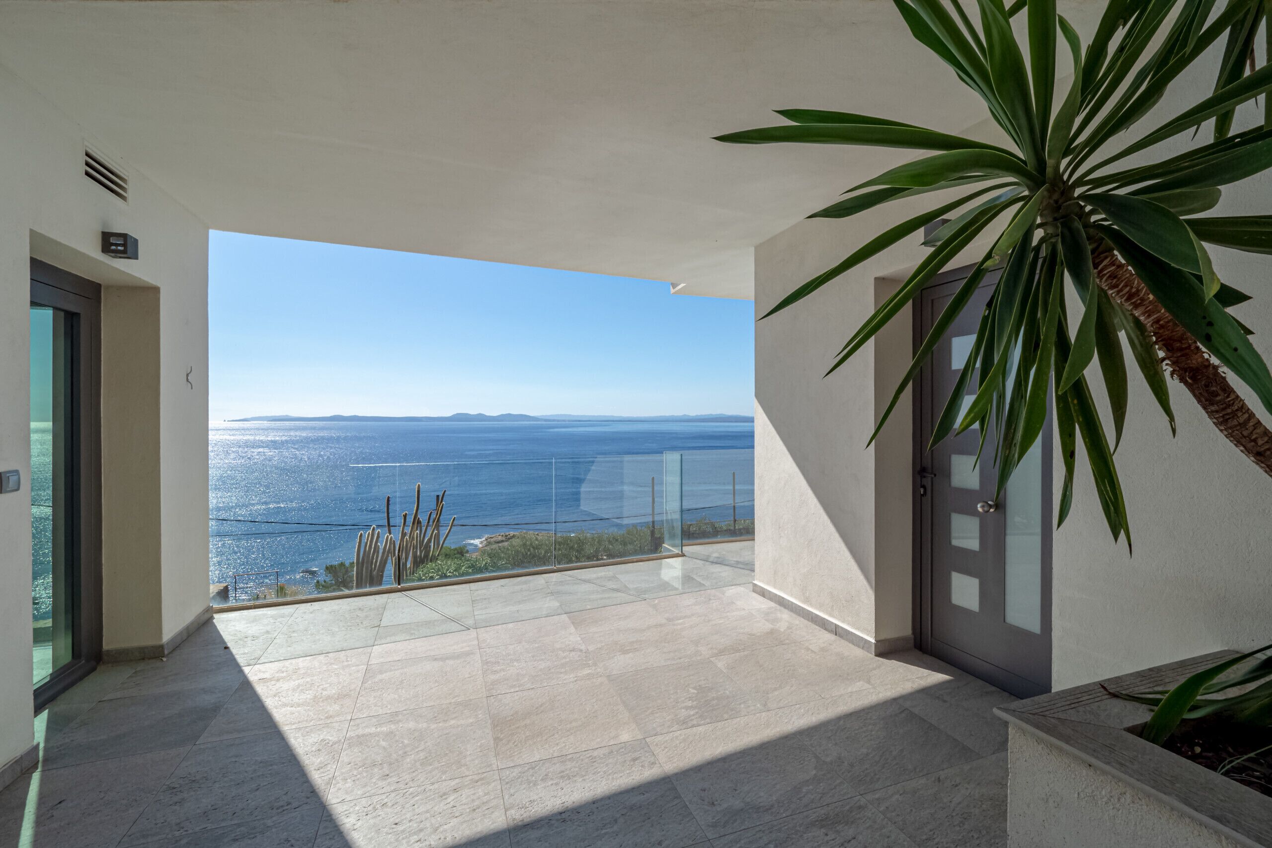 A spacious balcony with a clear view of the sea and distant land.