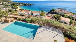 Una piscina con vistas al mar y a un pueblo costero.