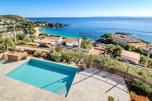 A swimming pool with a view of the sea and a coastal town. - VILLA VELAZQUEZ Roses (Rosas / Roses)