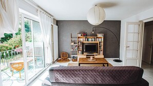Una sala de estar moderna con un sofá, un televisor y una estantería.