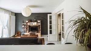 Un salón con chimenea, estanterías, un sofá y una planta grande.