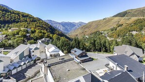 Un quartier résidentiel avec des maisons modernes, un parking et un paysage montagneux en arrière-plan.