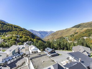 Zona residencial com casas modernas, estacionamento e montanhas ao fundo.