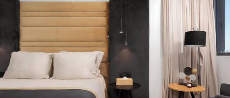 A modern bedroom with a bed, bedside table, lamp, and curtains.