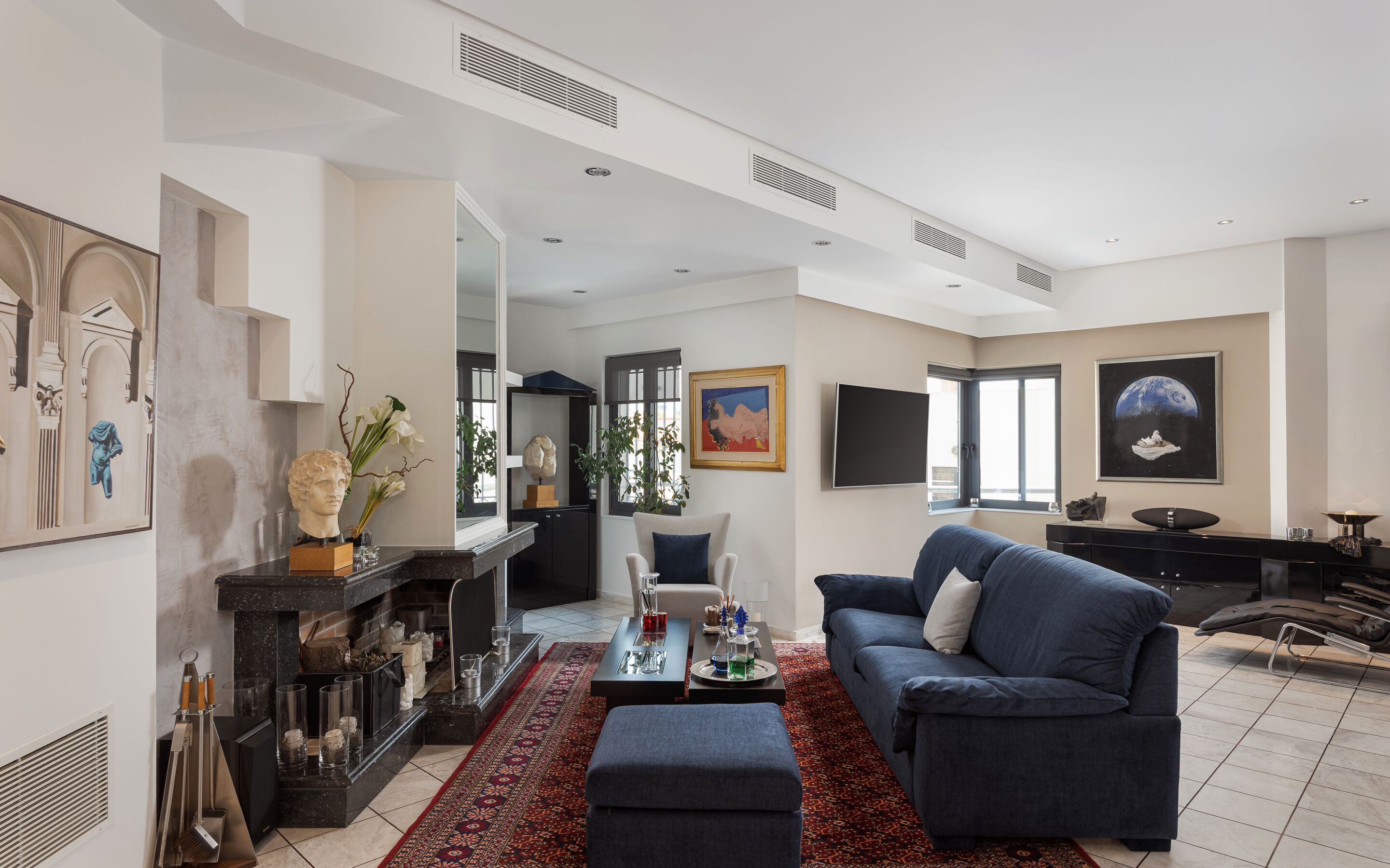Uma sala de estar moderna com um sofá azul, uma mesa de centro e uma lareira.