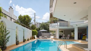 A swimming pool with a sunshade, lounge chairs, and potted plants. - Athenian Riviera Luxurious Villa & Residence (Alimos)