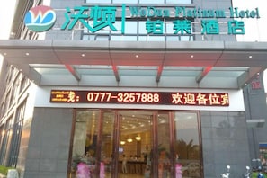 The exterior of the WoDun Platinum Hotel with a reception desk and glass doors. - Wodun Platinum Hotel (Qinzhou East Railway Station Niannianfeng Plaza) (Qinzhou)