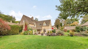 A stone house with a large garden and outdoor seating area. - Impressive five bedroom country home in the Cotswolds - Barnsley Cottage (Cirencester)