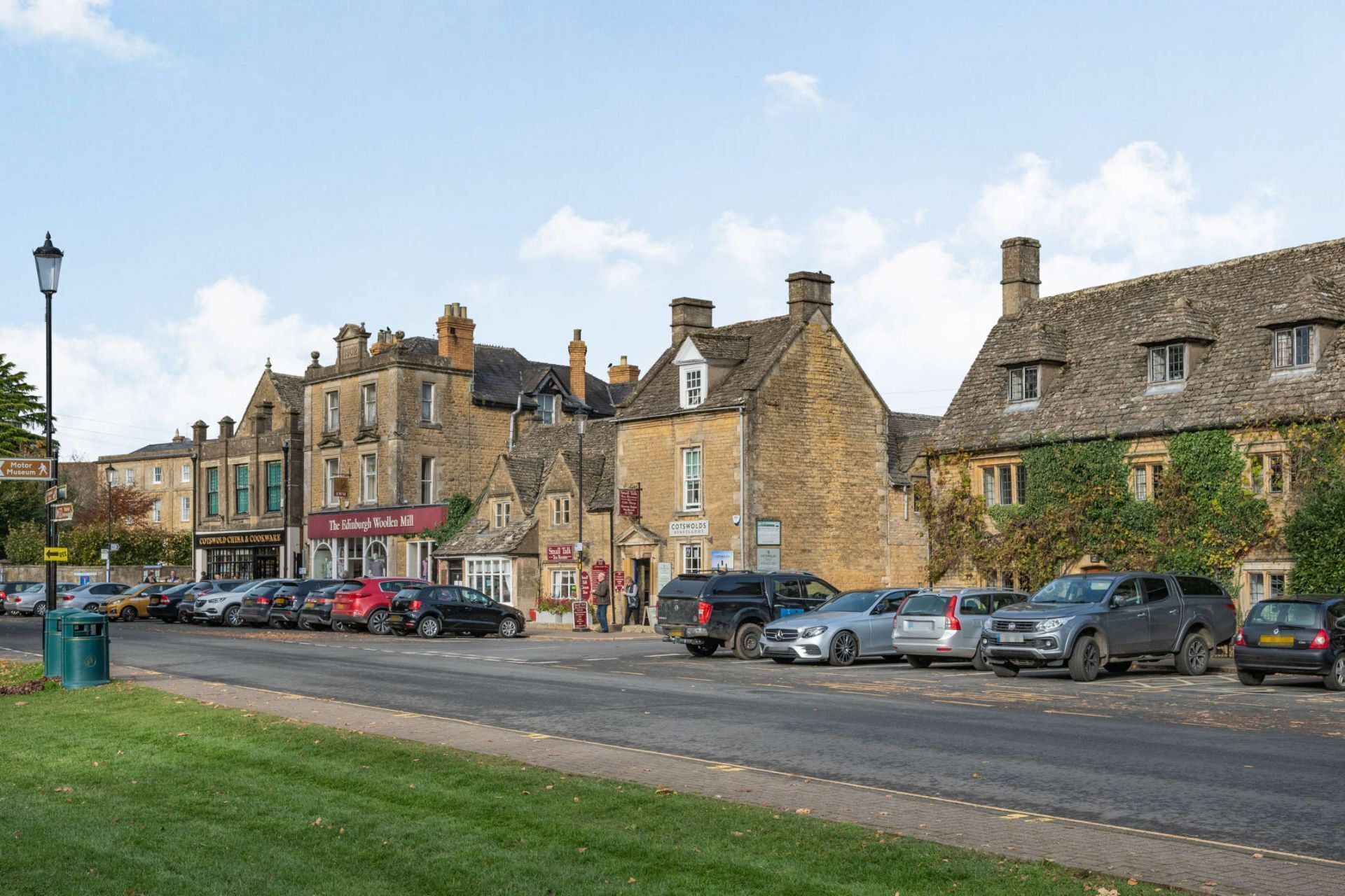 A street lined with historic stone buildings, including a sign for 'The Edinburgh Wooden Mill'.