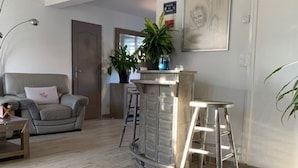 En stue med sofa, sofabord, stige og en plante.