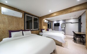A hotel room with two beds, a desk, and a TV. - Yeosu Hotel The B (Yeosu)