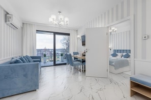 Una sala moderna con sofá, mesa de comedor y cama.