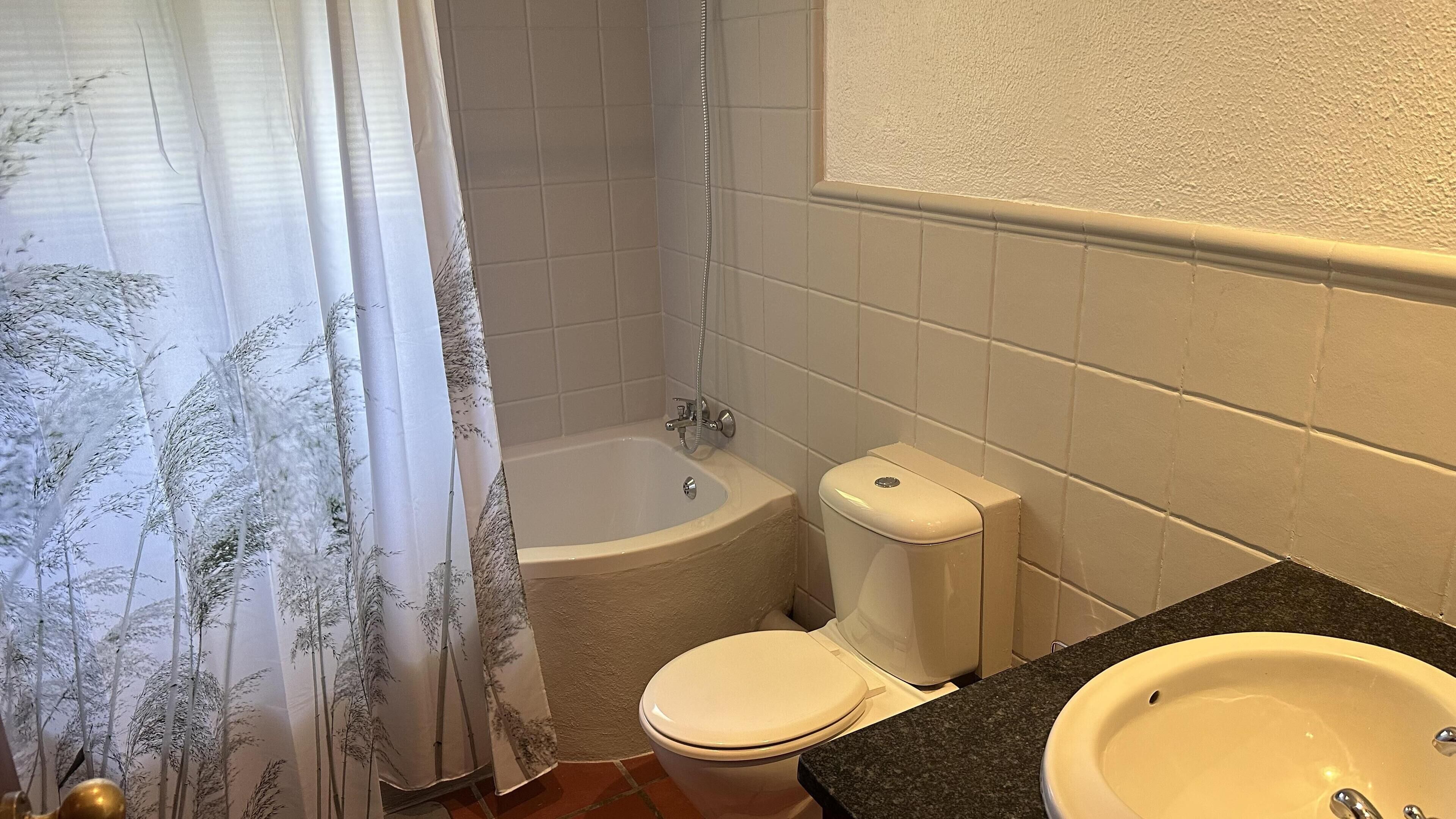Ein Badezimmer mit Badewanne, Toilette und Waschbecken.