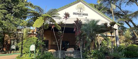 A resort building named Greenway Woods with a sign indicating a reception area and a playground.
