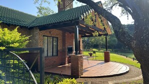 A brick building with a green tiled roof and a covered patio area. - Greenway Woods Self Catering Unit no 9, Whiteriver (Mbombela)