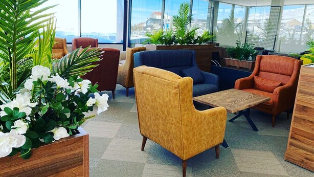 A modern lounge area with comfortable seating, large windows, and indoor plants. - Zumrut Palas Hotel (Kayseri)
