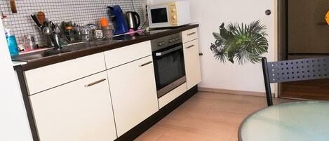 Apartamento | Cocina privada | Frigorífico, microondas, horno y placa de cocina