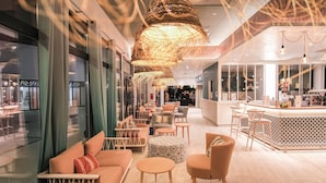 A modern interior with a bar area, seating arrangements, and large windows. - Belambra Clubs Port Camargue - Les Salins (Le Grau-Du-Roi)