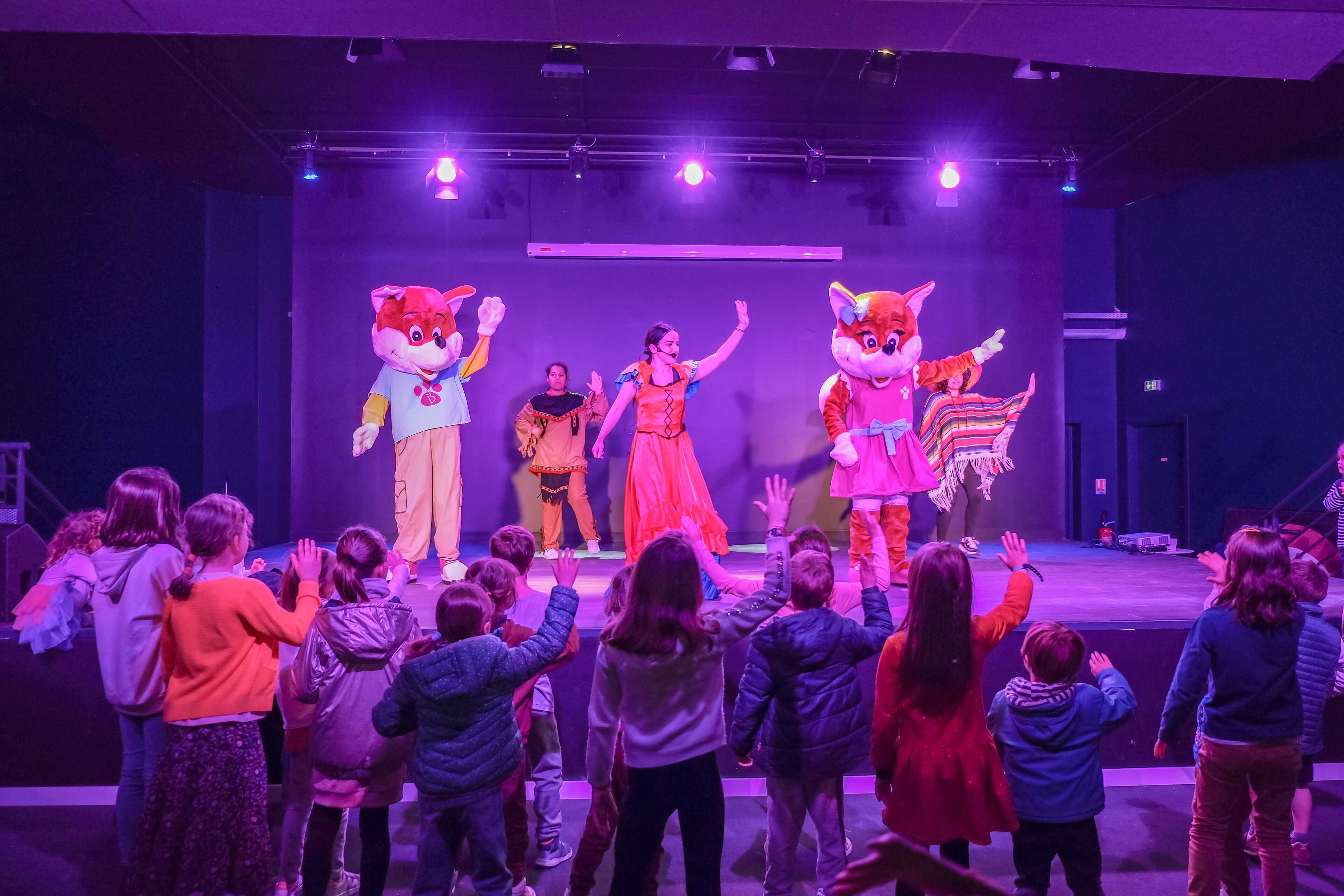A stage with performers and large mascot characters.